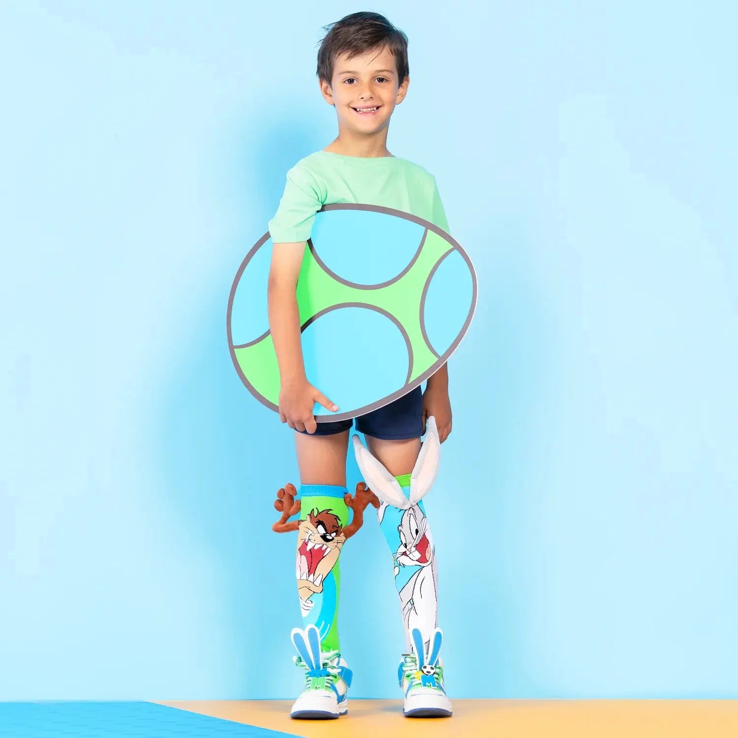 Dėvimos kojinės: vaikas dėvi BUGS BUNNY kojines – Zuikio Bugso atvaizdas ir ausytės išsiskiria dėvint.