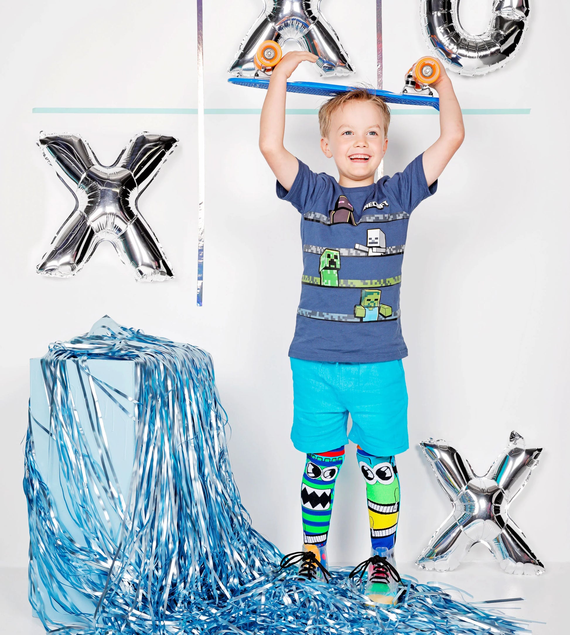 Dėvimos kojinės: vaikas mūvi kojines MONSTER, aiškiai matomi žaismingi monstrų veidukai abiejose kojose