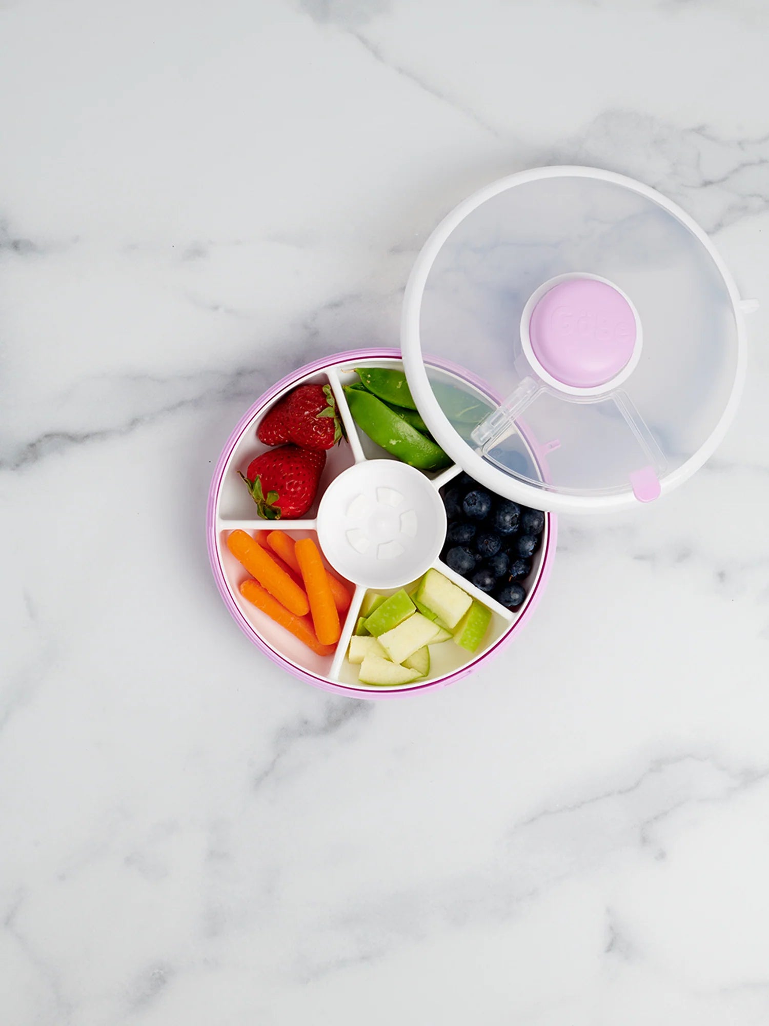 GoBe Snack Spinner in lilac with assorted fruits and veggies, including strawberries, blueberries, carrots, and apples.